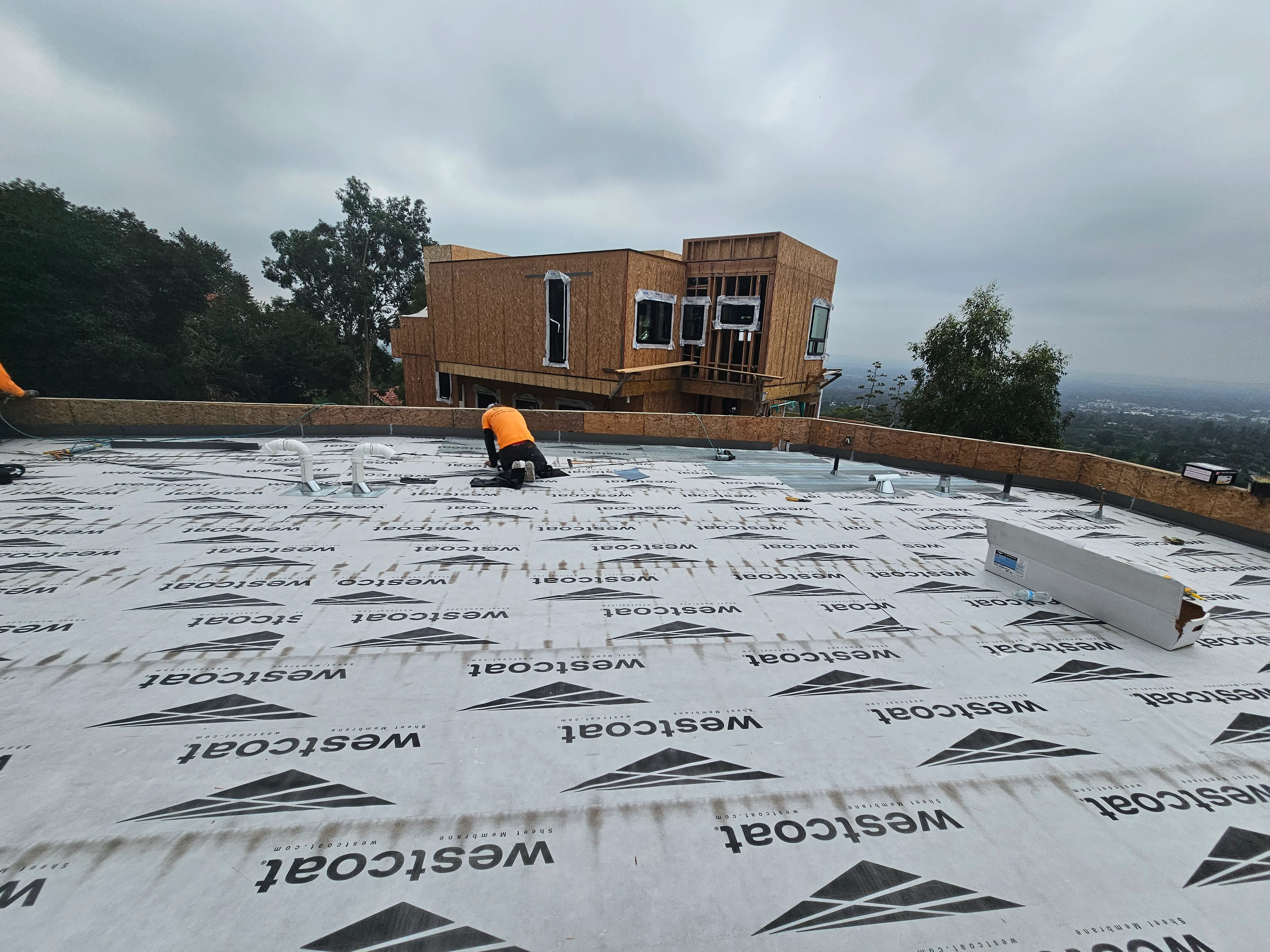 A large flat commercial roof with a high-performance white waterproofing membrane