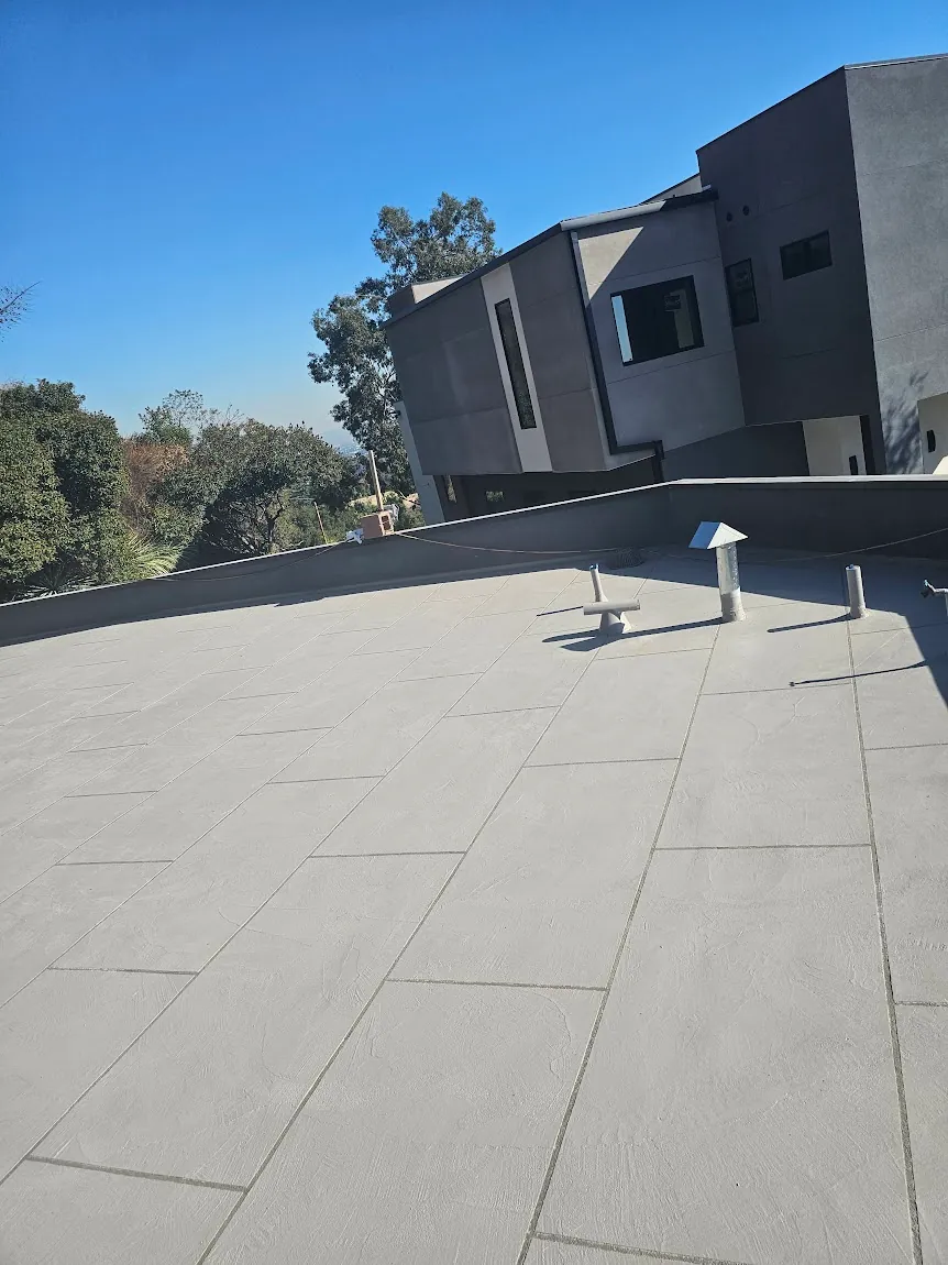 Contractor applying elastomeric liquid membrane to a rooftop patio deck in Southern California.