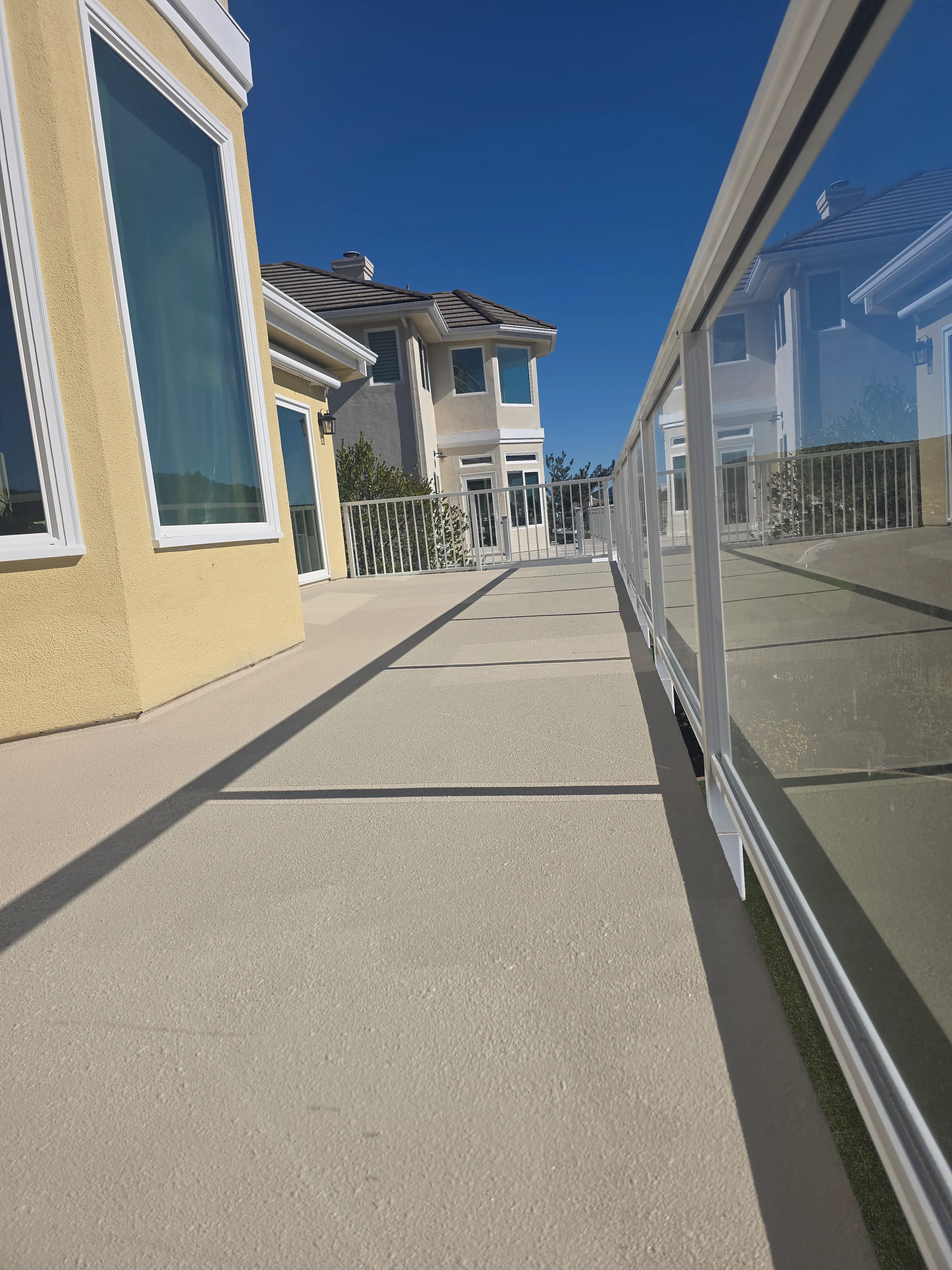 Waterproofing team applying non-slip walking deck coating to an elevated HOA breezeway in Orange County.